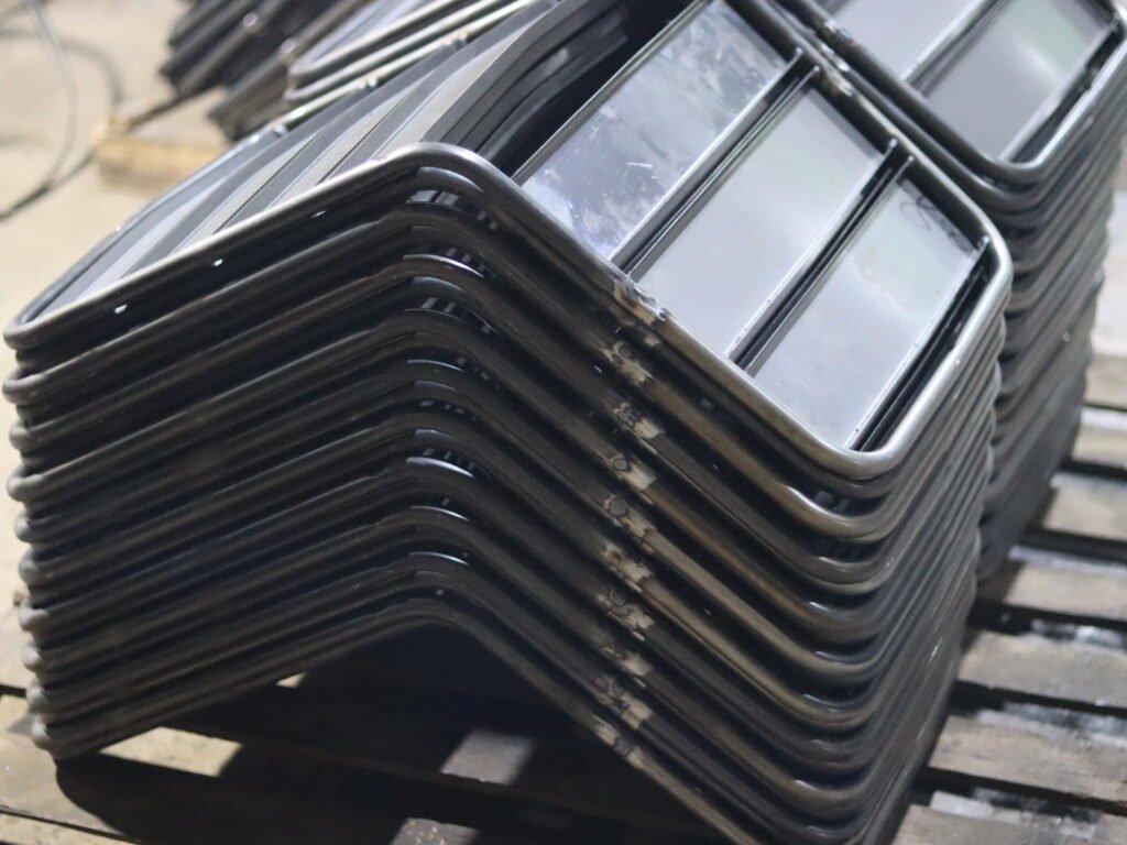 Cadres de chaises métalliques empilés lors de la fabrication de meubles d'extérieur
